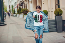 Attractive girl in a jeans jacket and white t-shirt walking along the street. Mock-up.