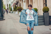 Attractive girl in a jeans jacket and white t-shirt walking along the street. Mock-up.