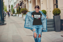 Attractive girl in a jeans jacket and white t-shirt walking along the street. Mock-up.