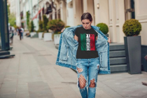 Attractive girl in a jeans jacket and white t-shirt walking along the street. Mock-up.